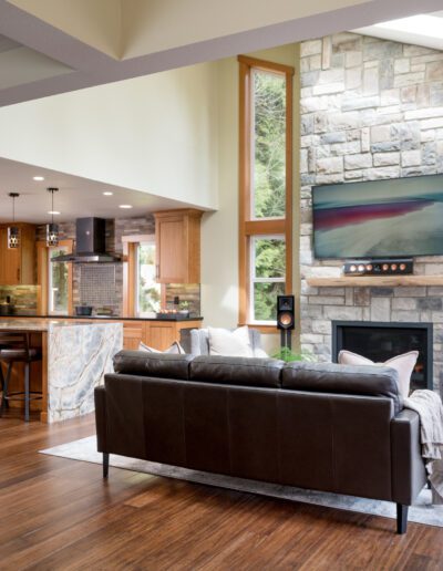 A living room with hardwood floors and a stone fireplace.