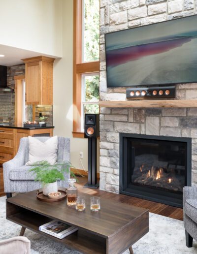 A living room with a stone fireplace and tv.