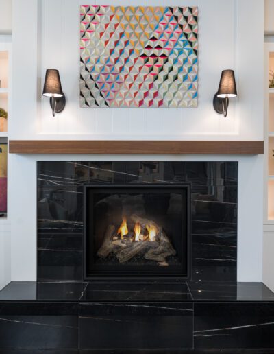 A living room with a fireplace and black shelves.