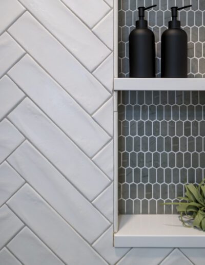 A bathroom with a herringbone tiled wall.