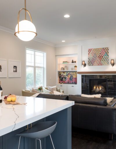 A living room with a fireplace and a kitchen island.