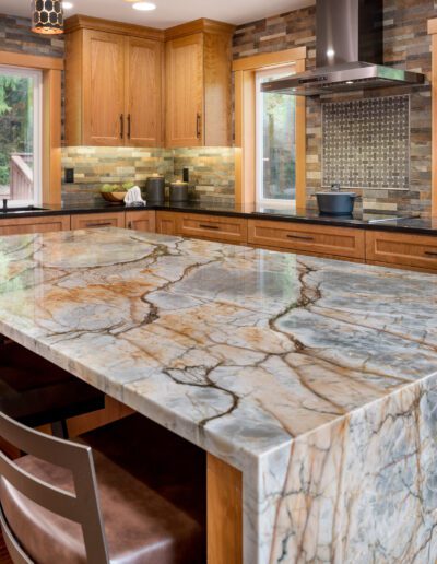 A kitchen with marble counter tops and wooden cabinets.