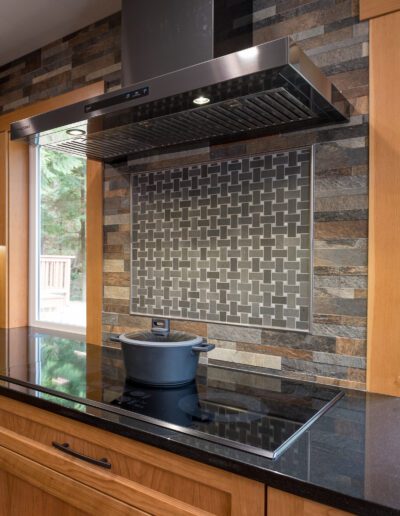 A kitchen with black cabinets and a stove top.