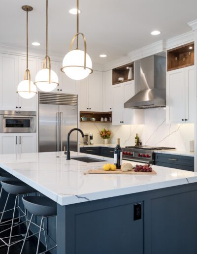 A kitchen with a blue island and white cabinets.