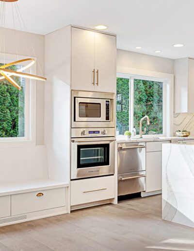 A white kitchen with a bench and a window.