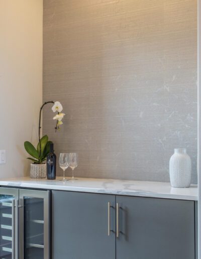 A gray kitchen with a wine cooler.