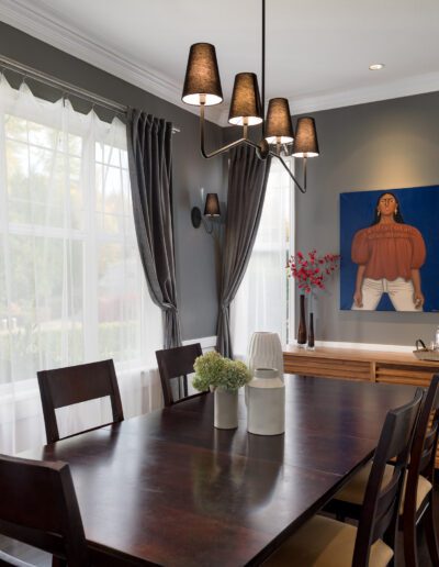 A dining room with a painting on the wall.