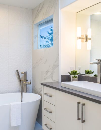 A modern bathroom with a white tub and sink.