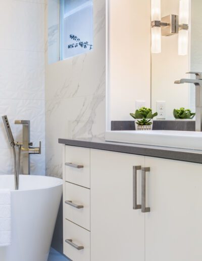 A modern bathroom with a white tub and sink.