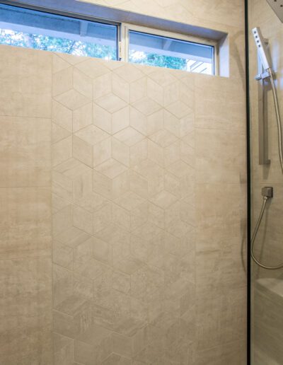 A bathroom with a walk in shower and a window.