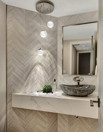 A bathroom with a marble sink and mirror.