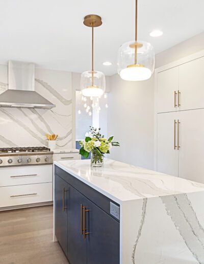 A kitchen with marble counter tops and stainless steel appliances.