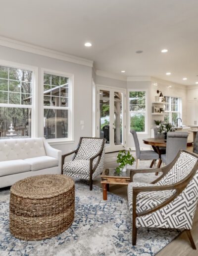 A living room with hardwood floors and white furniture.