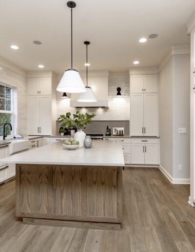 A white kitchen with wood floors and a center island.