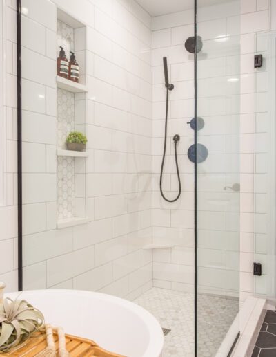 A white and black bathroom with a glass shower stall.