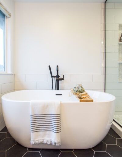 A black and white bathroom with a white tub.