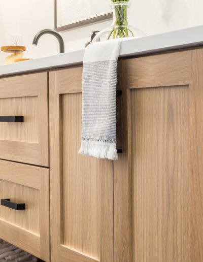 A bathroom with wooden cabinets and a towel rack.