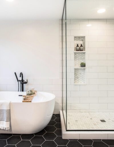 A black and white bathroom with a tub and glass shower.