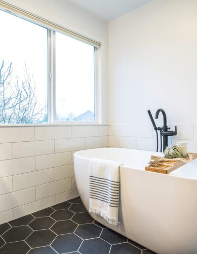 A black and white bathroom with a tub and sink.