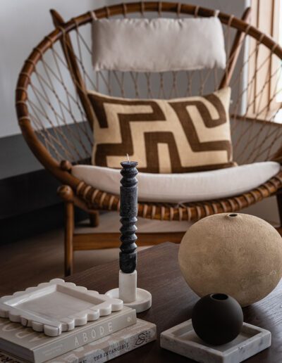 A living room with a wicker chair and a candle.