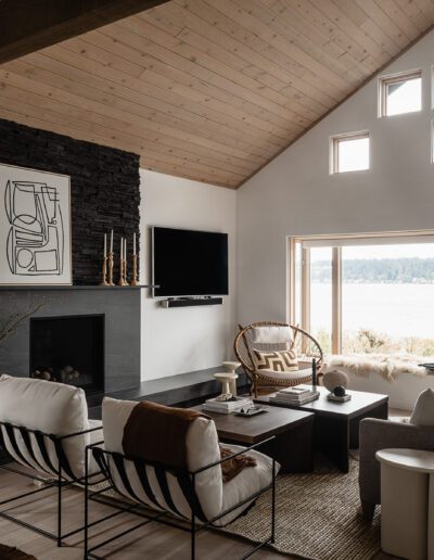 A living room with wood beams and a fireplace.