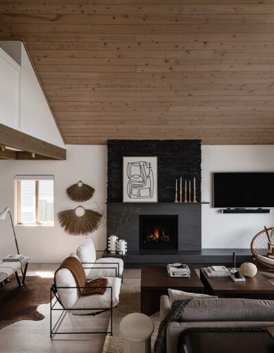 A living room with wood ceilings and a fireplace.