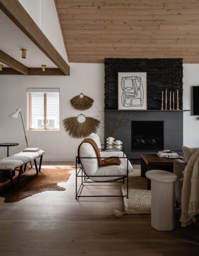 A living room with wood ceilings and a fireplace.