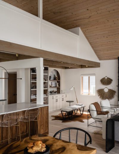 An open kitchen and living room with wood ceilings.