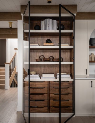 A wooden cabinet with glass doors in a kitchen.