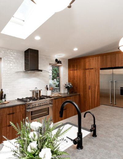 A modern kitchen with wood cabinets and a skylight.