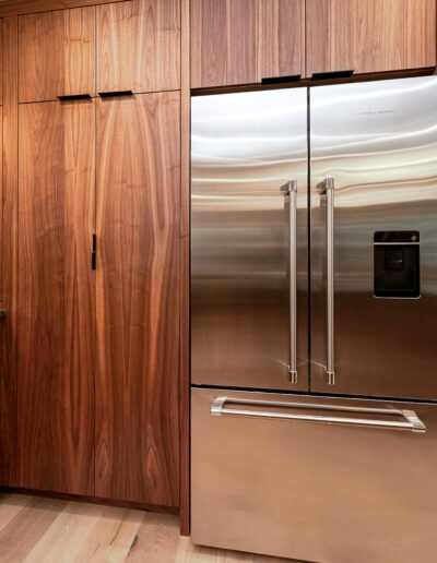 A kitchen with wooden cabinets and a stainless steel refrigerator.